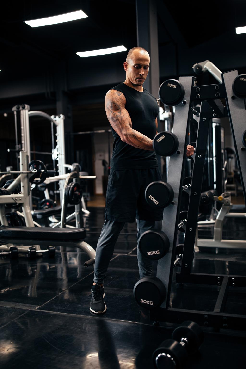 A man training with dumbbells in a modern gym
